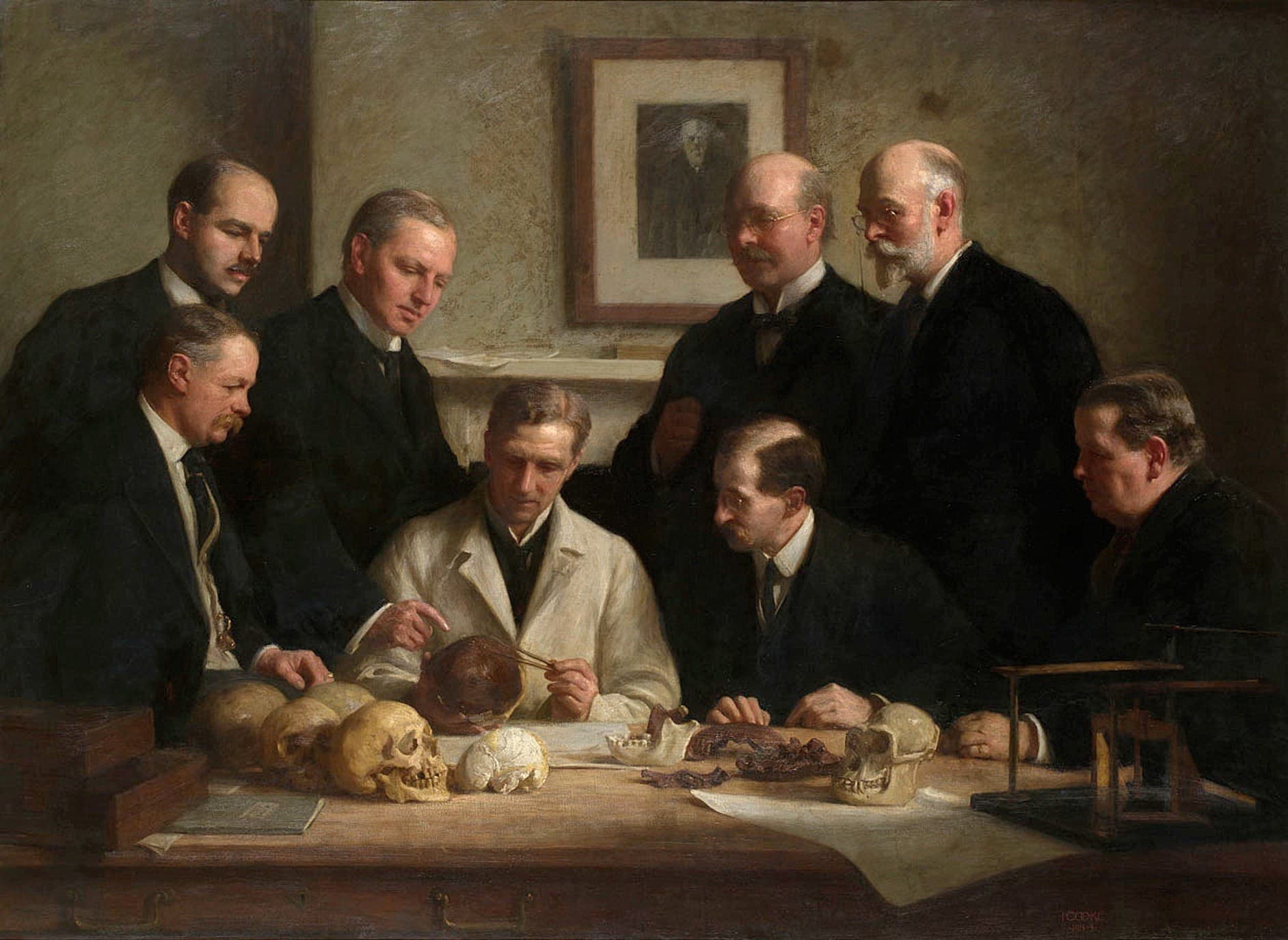 The portrait painted by John Cooke in 1915. Back row: (left to right) F. O. Barlow, G. Elliot Smith, Charles Dawson, Arthur Smith Woodward. Front row: A. S. Underwood, Arthur Keith, W. P. Pycraft, and Sir Ray Lankester. Note the painting of Charles Darwin on the wall.